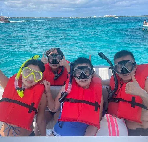 Kids and adults in snorkel masks and life vests ready to snorkel near Nassau, Bahamas