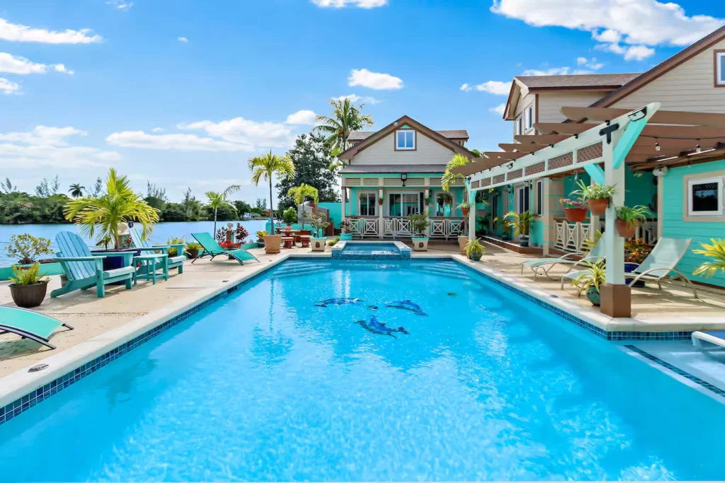 Waterfront vacation home with a turquoise pool and lounge chairs, Nassau, Bahamas