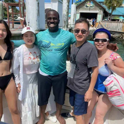 Guests posing with their captain at a marina dock before a private charter, Nassau, Bahamas