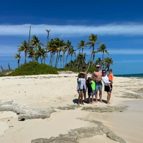 Family on a tiny palm-dotted sandbar island near Nassau, Bahamas