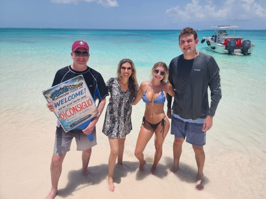Guests holding their welcome sign on a white sand beach near Nassau