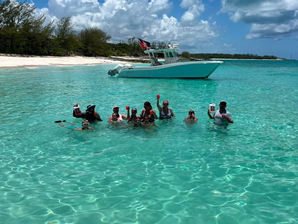 Group relaxing in clear water with the charter boat anchored nearby