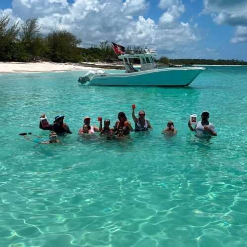 Group relaxing in clear water with the charter boat anchored nearby