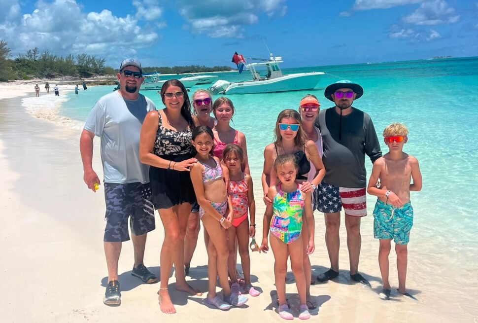Family on a white sand beach during an island hopping tour near Nassau, Bahamas