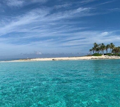 Tiny palm-dotted sandbar island near Nassau, Bahamas