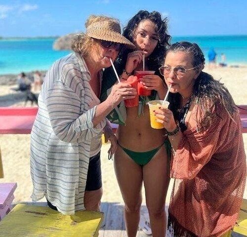 Friends sipping tropical drinks at a beach bar stop on a full-day tour